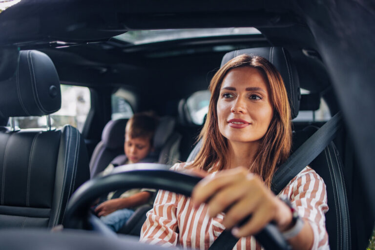 Woman driving car with her child in the backseat