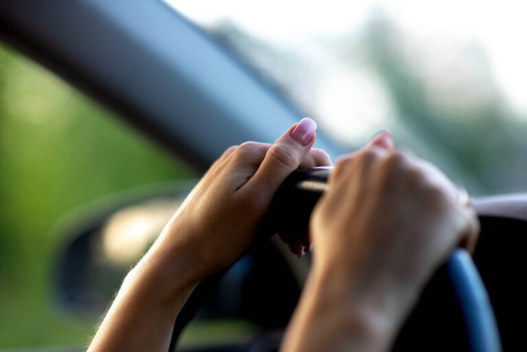 Woman's hands on steering wheel